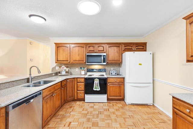 kitchen with light stone counters, ornamental molding, stainless steel appliances, sink, and light parquet flooring