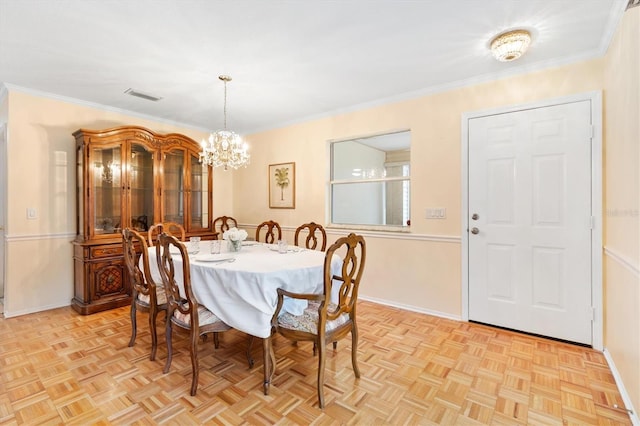 dining space featuring light parquet flooring, a chandelier, and ornamental molding