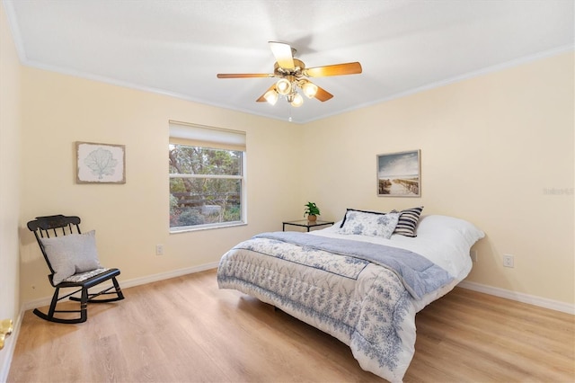 bedroom with light hardwood / wood-style flooring, ceiling fan, and crown molding