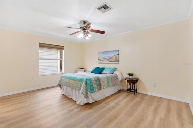 bedroom with ceiling fan, ornamental molding, and light hardwood / wood-style flooring