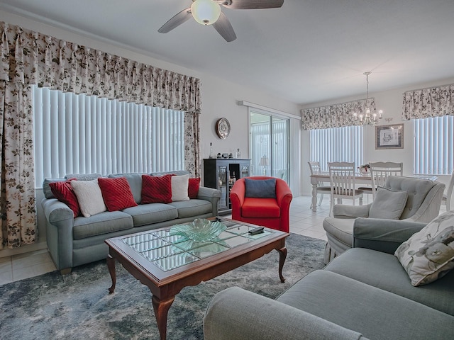 tiled living room with ceiling fan with notable chandelier