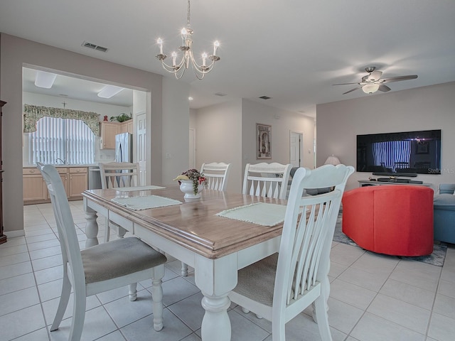 tiled dining space with ceiling fan with notable chandelier