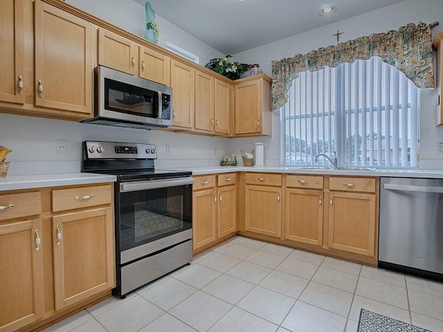 kitchen with sink, light tile patterned floors, and appliances with stainless steel finishes