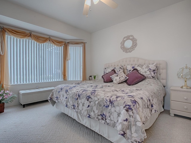 bedroom featuring light colored carpet, ceiling fan, and multiple windows