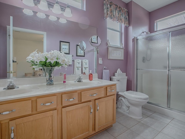 bathroom featuring vanity, tile patterned flooring, a shower with shower door, and toilet