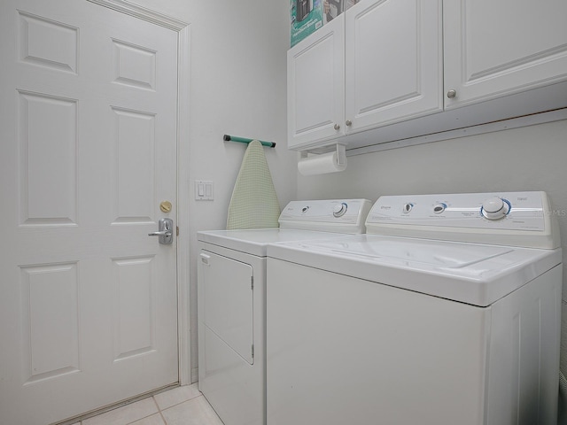 washroom with cabinets, separate washer and dryer, and light tile patterned floors