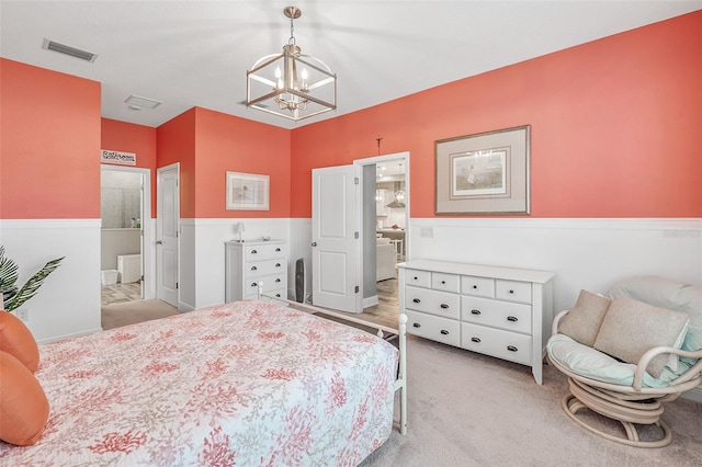 carpeted bedroom featuring ensuite bathroom and a chandelier