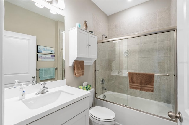 full bathroom featuring toilet, bath / shower combo with glass door, and vanity