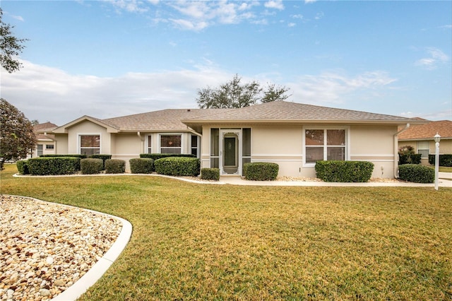 ranch-style house featuring a front yard and stucco siding