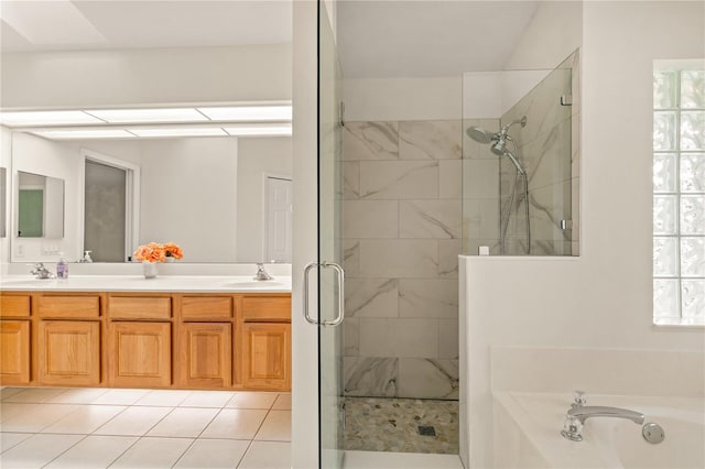 full bath featuring a garden tub, a sink, a healthy amount of sunlight, a tile shower, and double vanity