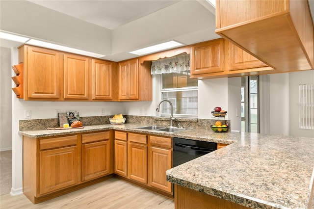 kitchen with dishwasher, a sink, a wealth of natural light, and light wood-style floors