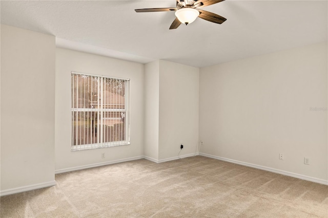 empty room featuring light carpet, ceiling fan, and baseboards