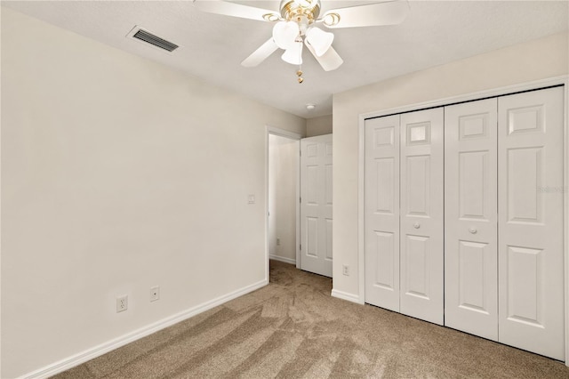 unfurnished bedroom featuring visible vents, baseboards, ceiling fan, carpet, and a closet