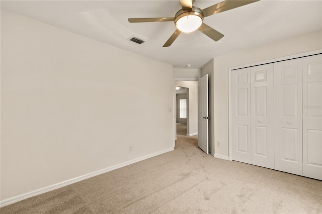 unfurnished bedroom with carpet flooring, a ceiling fan, visible vents, baseboards, and a closet