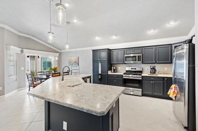 kitchen with decorative light fixtures, vaulted ceiling, sink, an island with sink, and stainless steel appliances