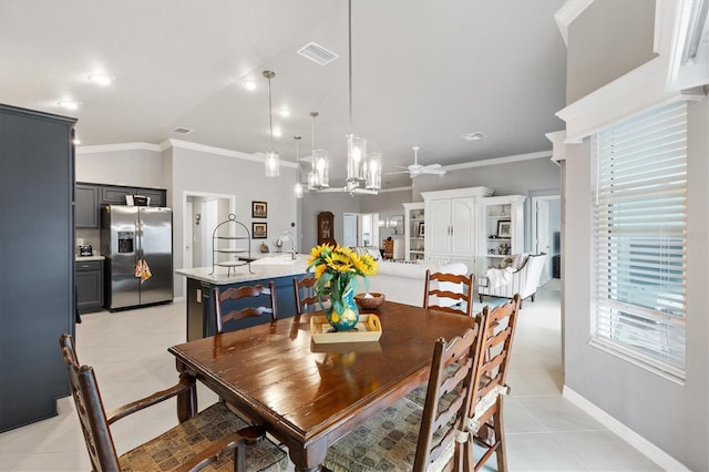 tiled dining room featuring lofted ceiling, ceiling fan, and ornamental molding