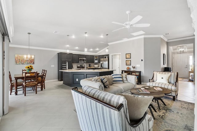 living room featuring ceiling fan with notable chandelier, sink, light tile patterned floors, and crown molding