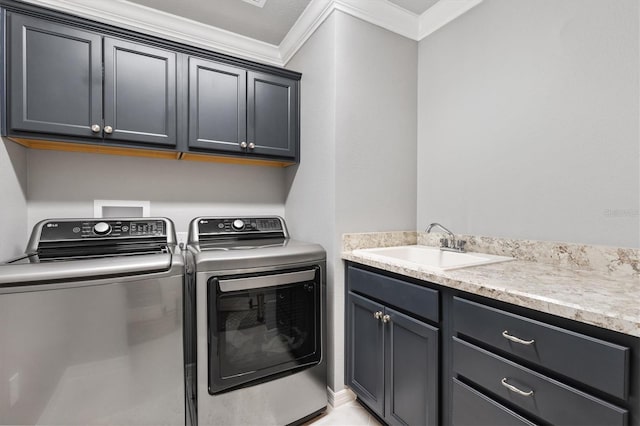 clothes washing area featuring washer and clothes dryer, sink, ornamental molding, and cabinets