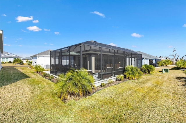 rear view of property featuring a lanai and a yard