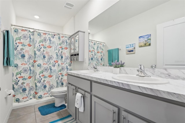 bathroom featuring toilet, vanity, tile patterned floors, and walk in shower