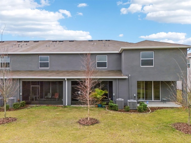 rear view of house with central AC, a patio, and a lawn