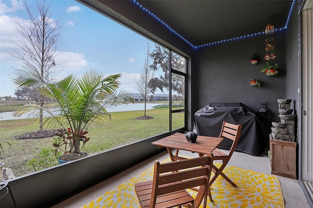 sunroom / solarium featuring a water view