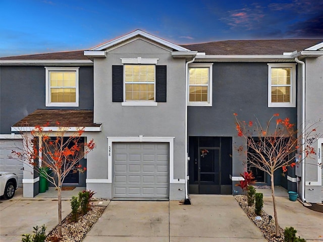 view of property with an attached garage and stucco siding