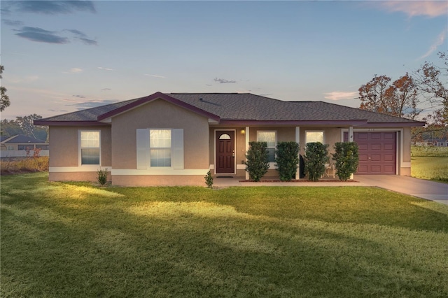 ranch-style home with a garage and a yard