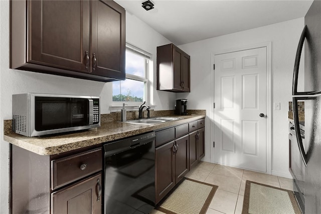 kitchen featuring light tile patterned floors, dark brown cabinets, black appliances, and sink