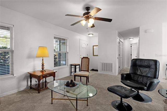 sitting room with plenty of natural light, light colored carpet, and ceiling fan