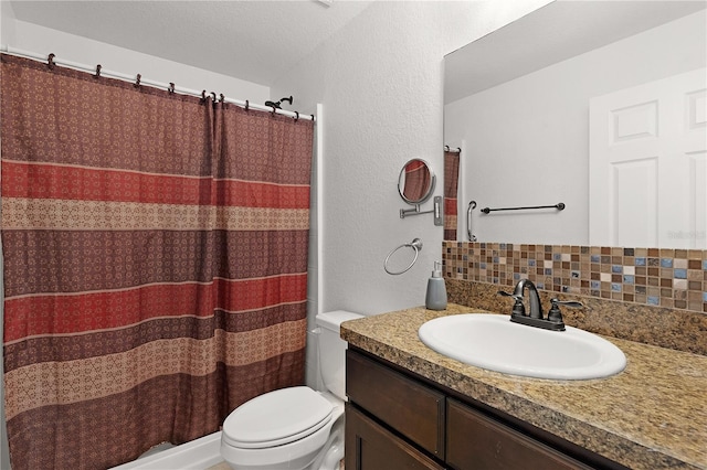 bathroom featuring vanity, backsplash, and toilet