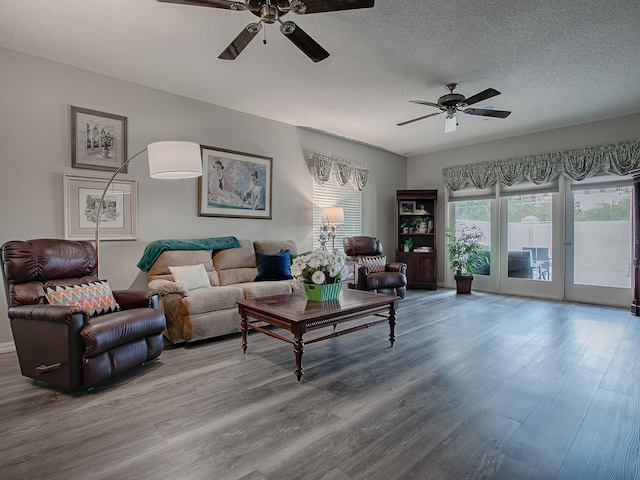 living room with wood-type flooring, a textured ceiling, and ceiling fan