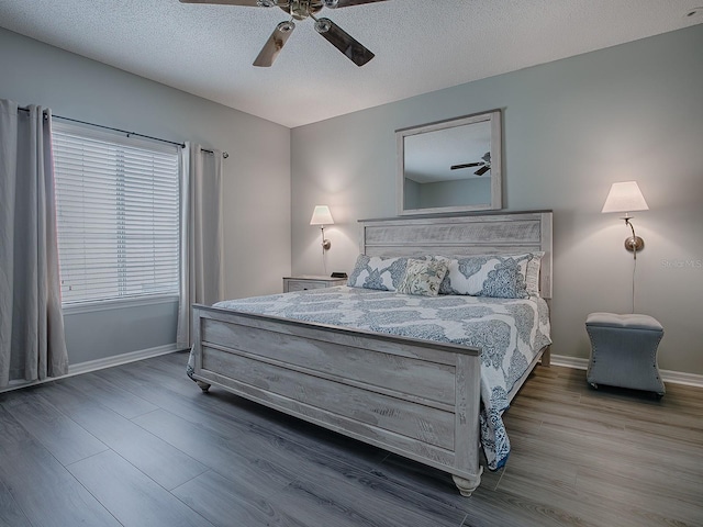 bedroom with a textured ceiling, ceiling fan, and hardwood / wood-style flooring