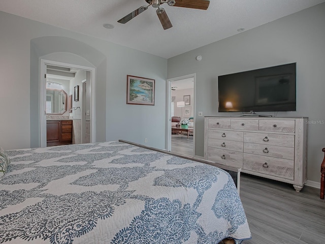 bedroom featuring ceiling fan, a textured ceiling, connected bathroom, and hardwood / wood-style floors