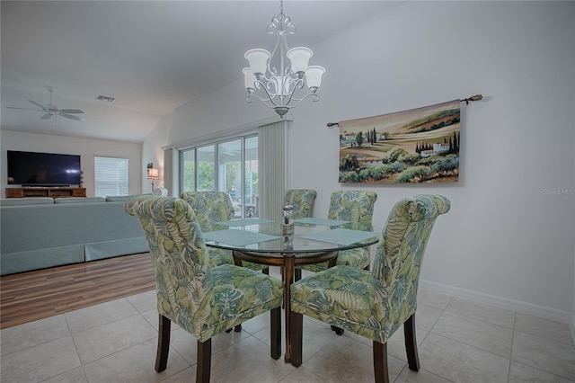 dining room featuring lofted ceiling, light tile patterned floors, and ceiling fan with notable chandelier