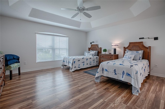 bedroom featuring ceiling fan, a tray ceiling, and hardwood / wood-style floors