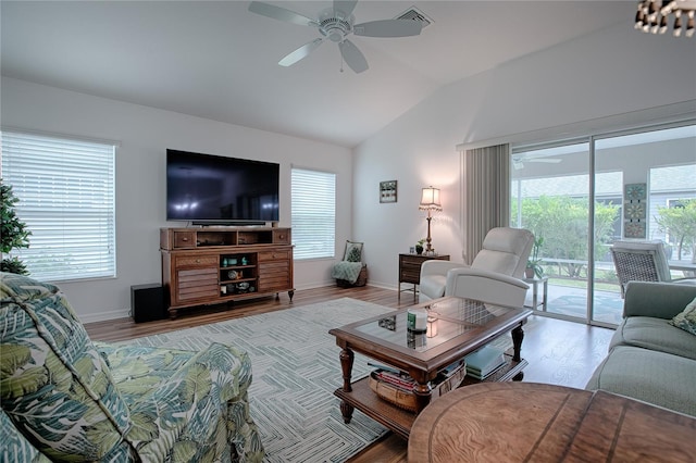 living room with light wood-type flooring, vaulted ceiling, and a wealth of natural light