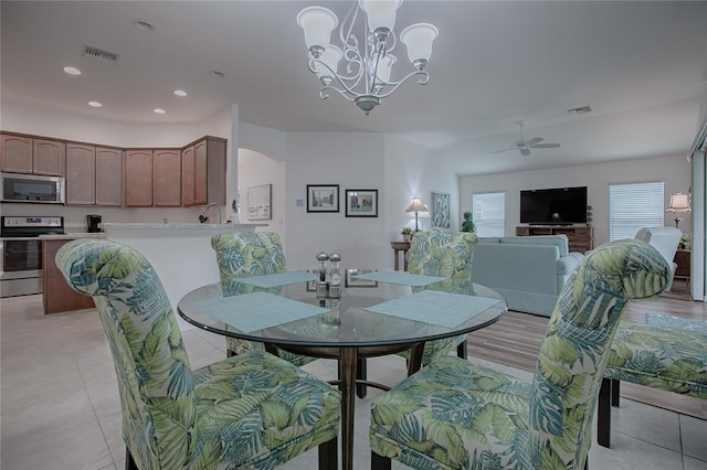 dining room with ceiling fan with notable chandelier and light tile patterned flooring