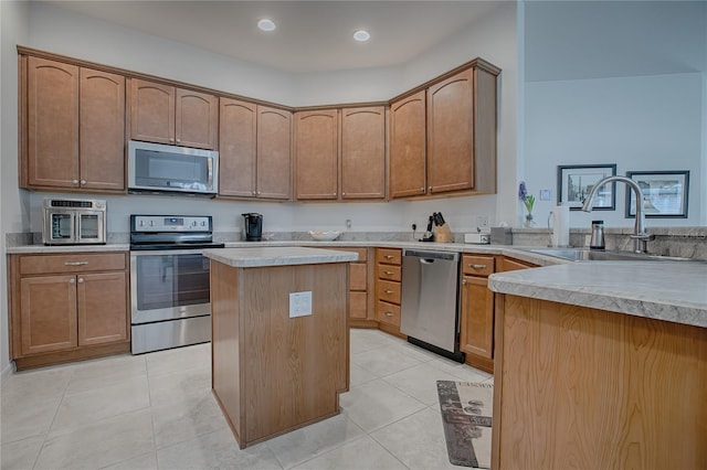 kitchen featuring light tile patterned floors, kitchen peninsula, stainless steel appliances, a kitchen island, and sink