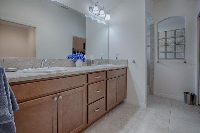 bathroom with a shower, vanity, and tile patterned flooring