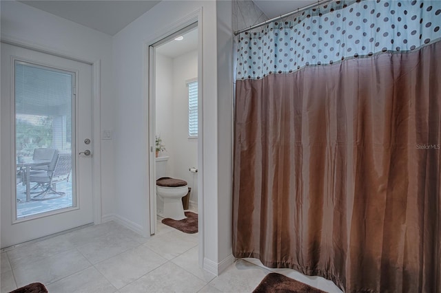 bathroom featuring toilet and tile patterned flooring