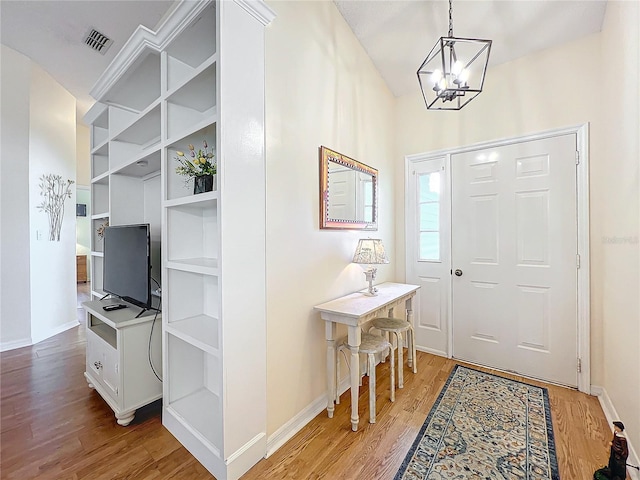 entryway featuring light wood-type flooring and a notable chandelier