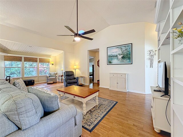 living room with lofted ceiling, a textured ceiling, ceiling fan, and light hardwood / wood-style floors