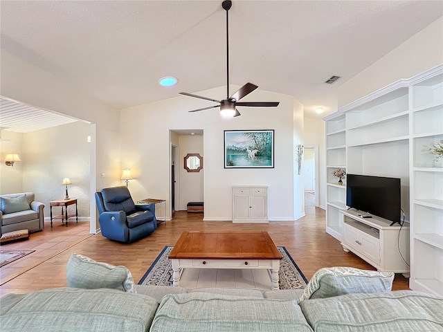 living room featuring lofted ceiling, ceiling fan, and light hardwood / wood-style floors