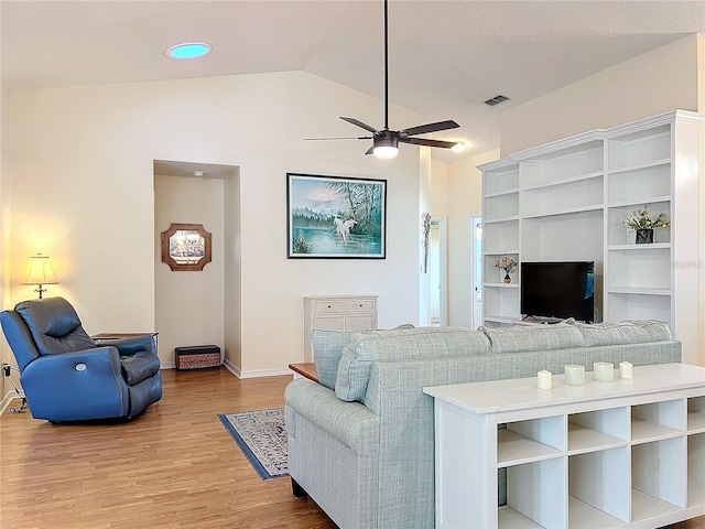 living room with ceiling fan, vaulted ceiling, and hardwood / wood-style flooring