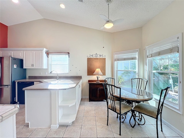 kitchen featuring kitchen peninsula, stainless steel fridge, white cabinetry, black dishwasher, and sink