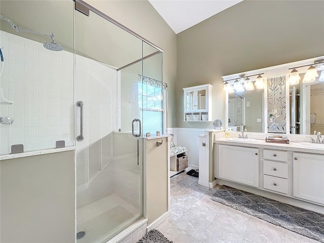 bathroom with a shower with door, vaulted ceiling, and vanity