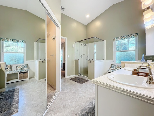 bathroom with high vaulted ceiling, vanity, walk in shower, and plenty of natural light