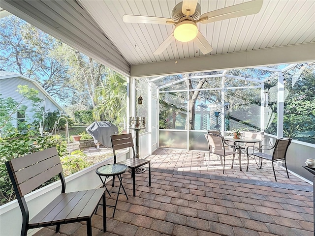 sunroom featuring ceiling fan and vaulted ceiling