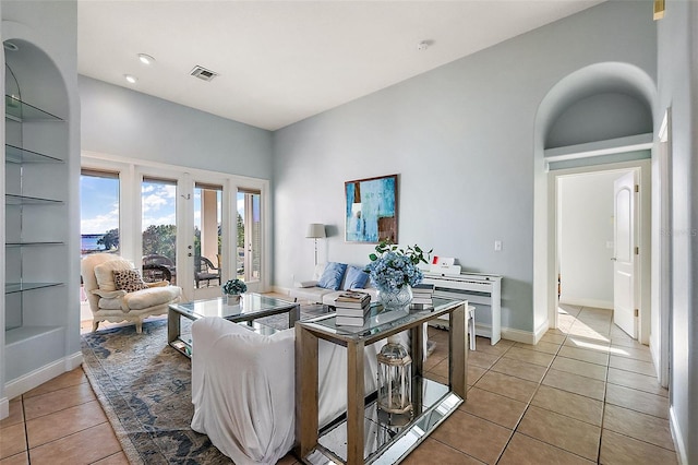 living room with french doors, light tile patterned flooring, and built in shelves